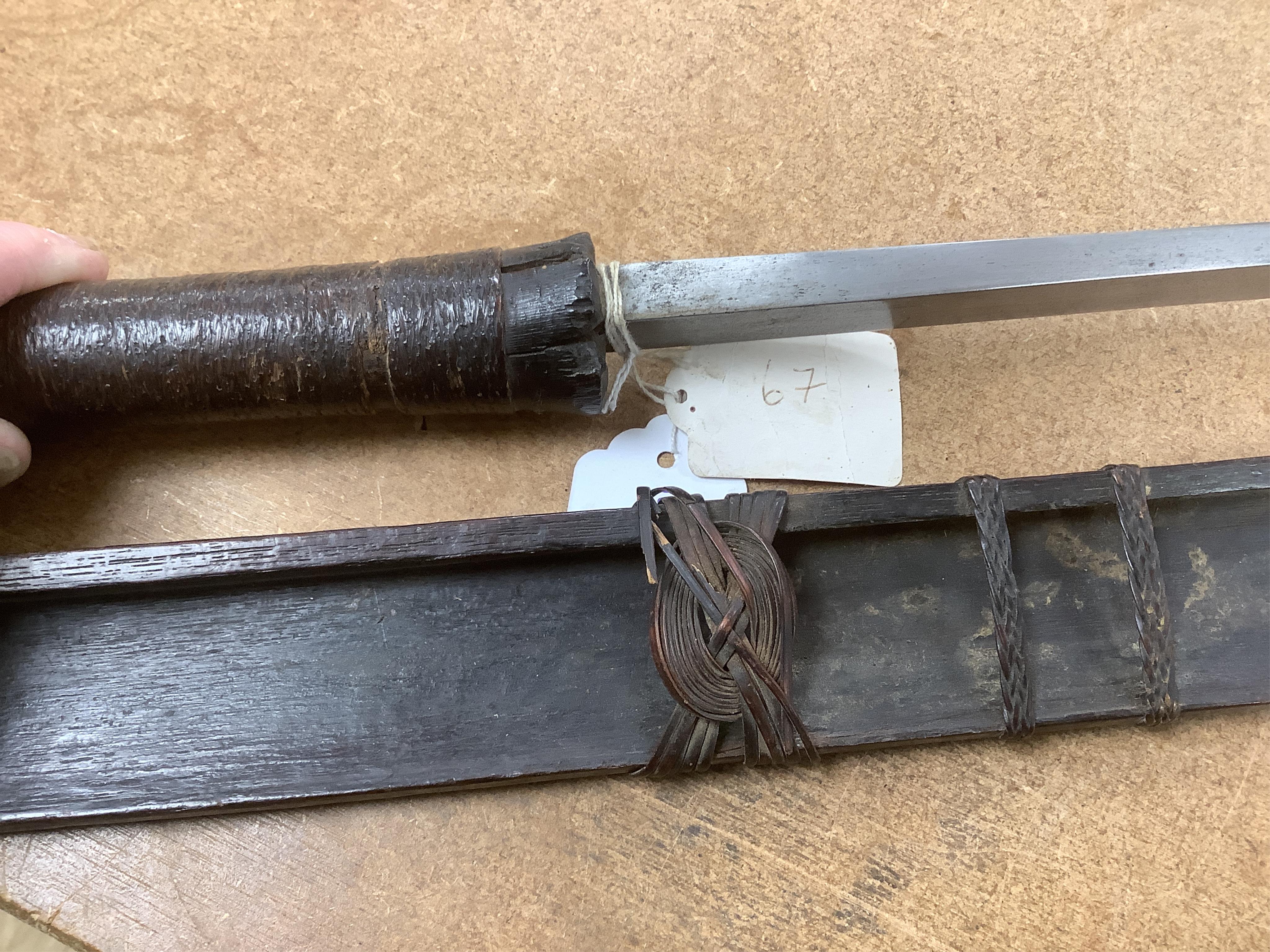 A 19th century Naga sword Dao, rattan bound wooden hilt in its open fronted wooden scabbard, blade 77cm. Condition - fair, some wear overall